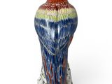 a vase with a bird on it on a white surface