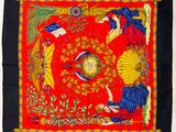une image représentant une écharpe rouge et jaune sur laquelle figurent les portraits d'une femme et d'un homme