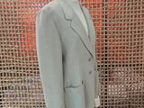 a suit on a mannequin stand in front of a mesh wall