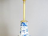 a blue and white table lamp with a white shade on it