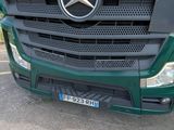 a green mercedes truck parked in a parking lot