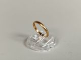 a gold ring sitting on top of a clear glass stand