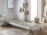 a white bed sitting in a room with a rug on the floor