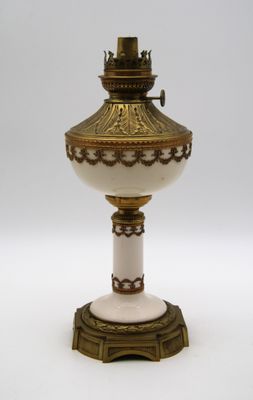 une lampe blanche et dorée posée sur une table blanche
