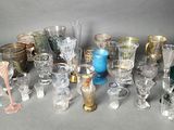 many different types of glasses and vases on the table