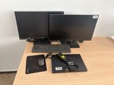 two computer monitors and a keyboard on a desk