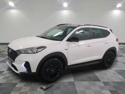 un 4x4 blanc garé sur un sol en damier dans un garage