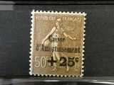 Trois timbres de couleurs différentes sont exposés dans une vitrine.