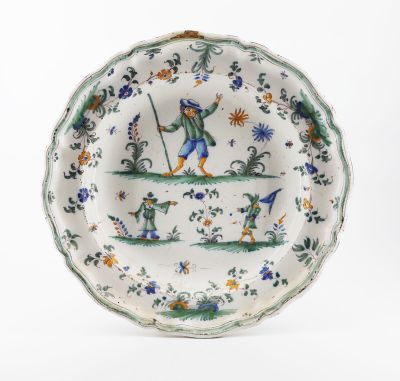 un gros plan d'une assiette décorée d'un oiseau et de fleurs