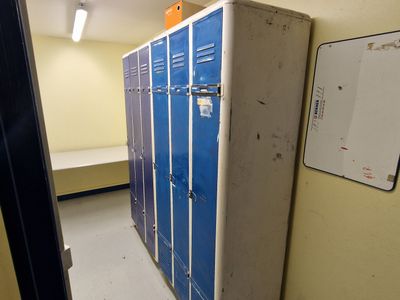 une pièce équipée de plusieurs casiers et d'un miroir