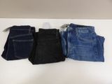 three pairs of jeans are lined up on a table