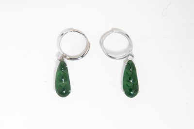 une paire de boucles d'oreilles en jade vert et argent sur fond blanc