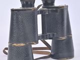 an old pair of black binoculars sitting on top of a white surface