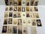 une vieille photo montrant un groupe d'hommes et de femmes assis sur une table
