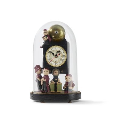 trois figurines sous un dôme en verre orné d'une horloge
