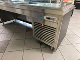 stainless steel counter top in a commercial kitchen with a glass display case