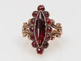 Gros plan sur une bague contenant une pierre rouge