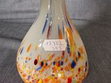 a glass vase with a label on it on a table