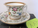 une tasse et une soucoupe posées sur un livre