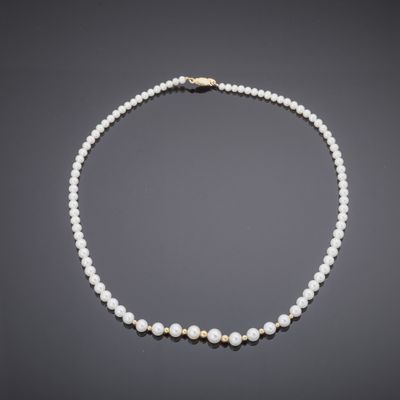 a cultured pearl necklace with a gold clasp