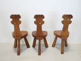 three wooden chairs sitting next to each other in a room