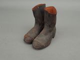 pair of brown leather boots with brown soles sitting on a white surface