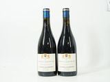 deux bouteilles de vin posées sur une table blanche