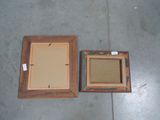 two picture frames sitting on the floor next to each other