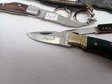 three different types of knives on a white table