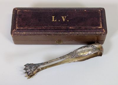 une cuillère en argent posée à côté d'une boîte sur une table