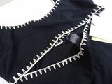 black and white dress with white stitching on it sitting on a table