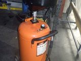 un réservoir orange surmonté d'une cuve noire, dans un garage