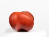two tomatoes sitting on top of each other on a block