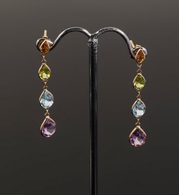 a pair of multicolored earrings on a black stand