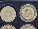 three gold coins in a black box with a picture of a man
