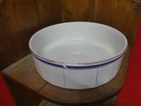 a white bowl with blue trim sitting on a wooden chair
