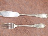 two forks and a spoon on a brown table