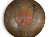 a metal plate with a painting on it on a white surface