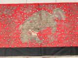 a red and black rug hanging on a wall