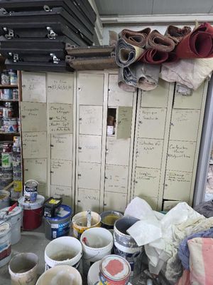 several buckets of paint are sitting on the floor in a room