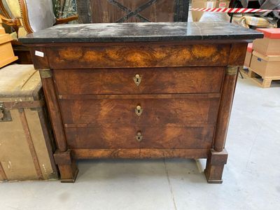 a wooden chest of drawers with a marble top