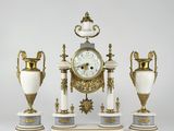 three vases and a clock sitting on top of each other