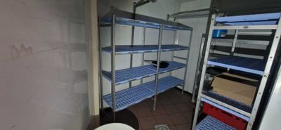 a small bathroom with a toilet and shelves in it