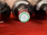 several bottles of wine are lined up on a red cloth