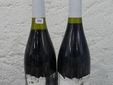 deux bouteilles de vin posées sur une table l'une à côté de l'autre