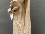 a mannequin wearing a beige trench coat and black pants