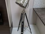 une lampe posée sur un trépied près d'une cheminée