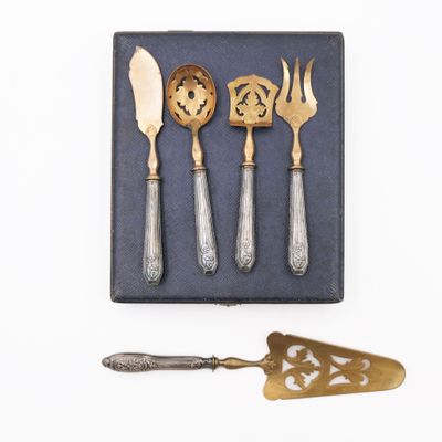 four silverware pieces in a box with a spoon and a spatula