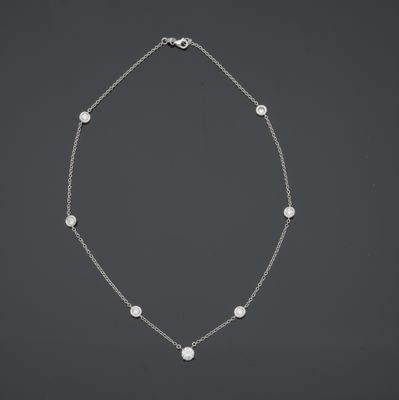 un collier de perles blanches et de diamants monté sur une chaîne en argent