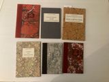 cinq livres exposés sur une table blanche